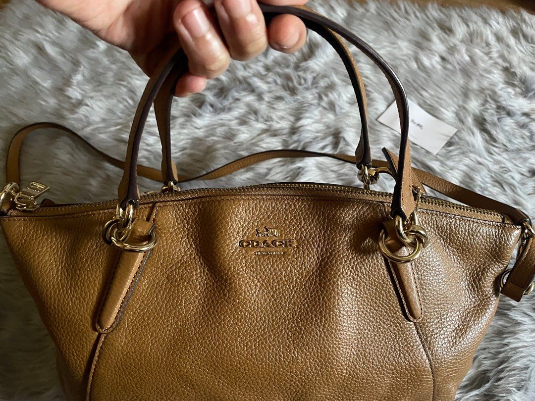 Coach Satchel Handbag (Category: Shoulder Bags) located in Taguig. Submitted by mdjpl (Listing ID 1292158369, Image 2). Description: Brown camel color Brand New, just stored with care instructions Handbag with crossbody strap RFS: Decluttering, selling low **if interested , please pay for shipping.