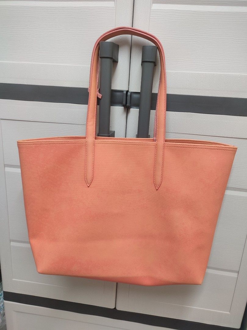Lacoste Anna Reversible Tote Bag (Category: Luxury Bags & Wallets) located in Quezon City. Submitted by karlleseshops (Listing ID 1293439037, Image 2). Description: Dimensions: 13.8 x 11.8 x 5.5" 2 handles Removable zipped pouch Crocodile branding PVC outer Outside: Pvc (100%) - reversible bag - guaranteed original never used. just opened and kept in closet. Bought from Japan. inclusions: - bag, color: pink- peach - tags - care booklet with flaw,