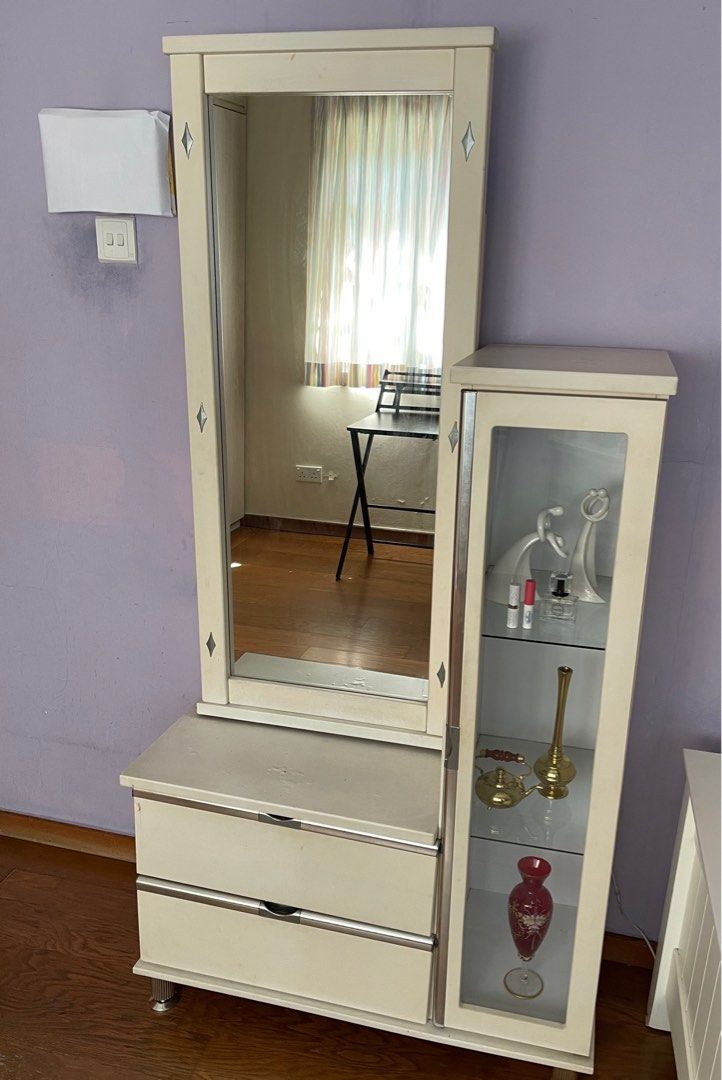 Dressing Table (Category: Other Home Furniture) located in Singapore. Submitted by springrain52 (Listing ID 1295082668, Image 1). Description: Very practical dressing table with 4 shelves of about 9 cm width, behind sliding mirror. Two handy drawers. The halogen lighting for glass cupboard is stunning. One leg was broken and now strengthened with tape. It holds steady. Paint on table top is swelling. .