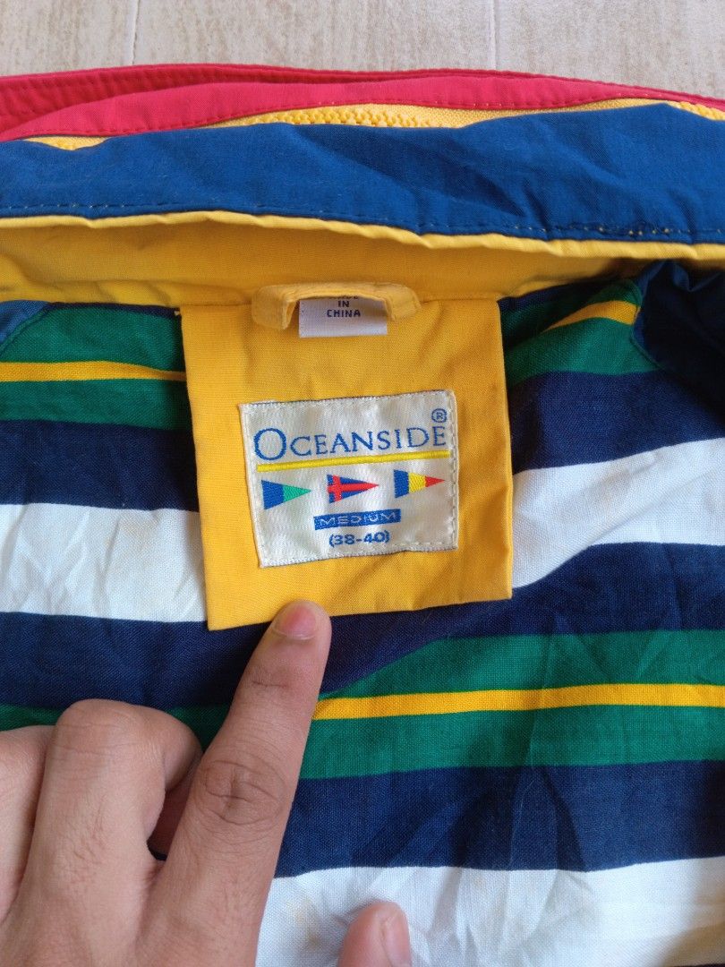 Vintage 90s Oceanside Sailing Windbreaker Jacket (Category: Coats, Jackets and Outerwear) located in Tagum. Submitted by _mr.thrifter (Listing ID 1295462329, Image 3). Description: Polyester cotton shell, cotton lining Full zip with hidden hood, side pockets Colorblock red, yellow blue Nautical themed.