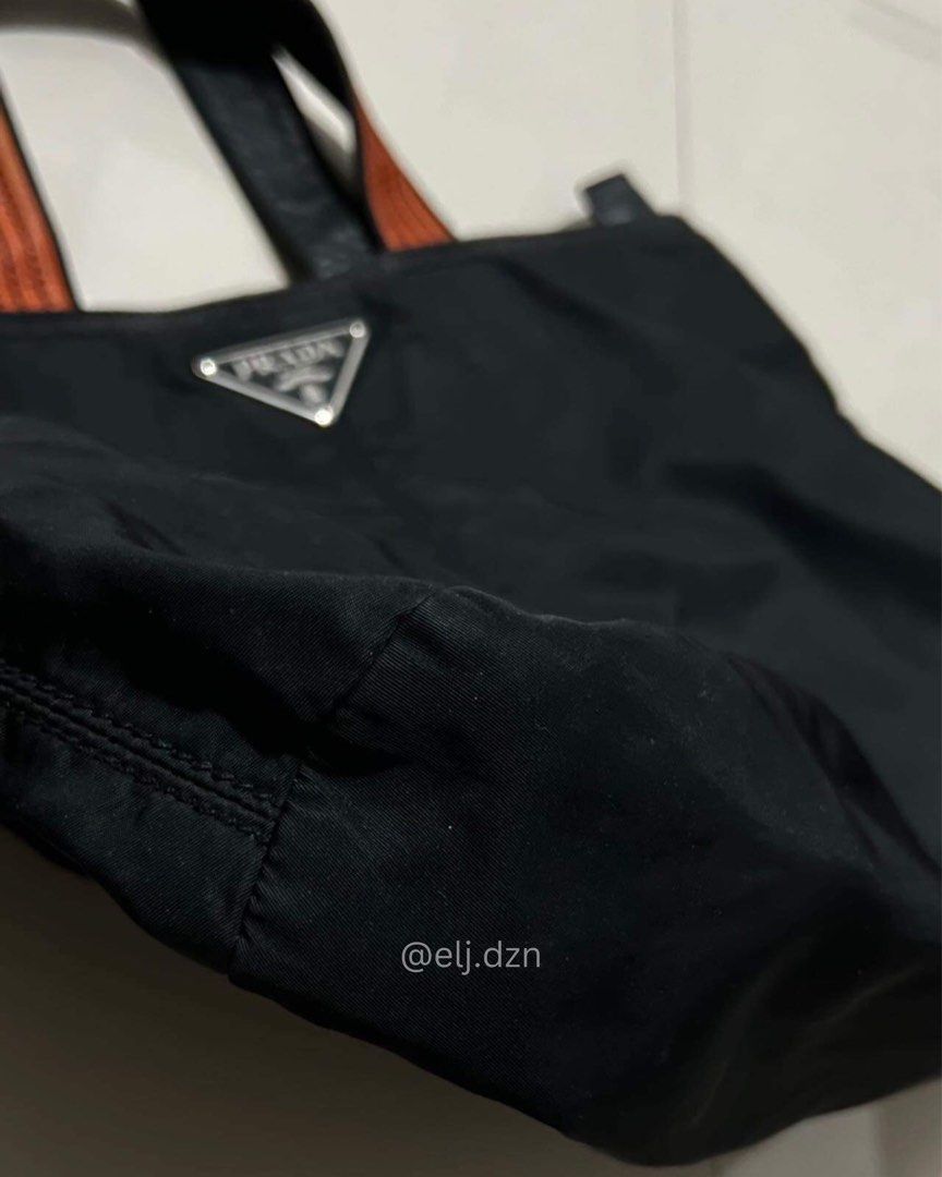 PRADA tota bag (Category: Luxury Bags & Wallets) located in Quezon City. Submitted by em.db (Listing ID 1295761279, Image 3). Description: PRADA BLACK NYLON TOTE Preloved - Authentic Also open for Authentication P13,000 only! Nego for sure buyer Quezon City 📍 No issue. Needs cleaning if maselan. Pero pwede na gamitin as is. Cash on delivery Cash on pick-up Meet up QC West Triangle / Fairview.
