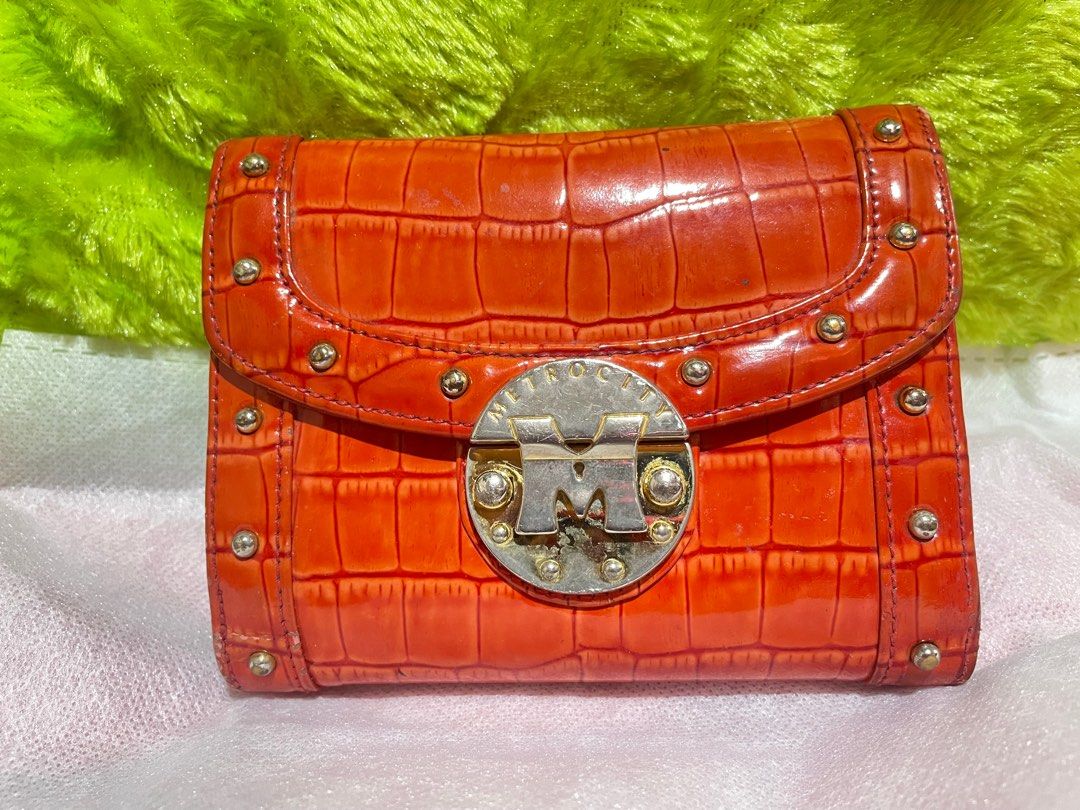 Metrocity wallet (Category: Luxury Bags & Wallets) located in Pasay City. Submitted by hearty12 (Listing ID 1291036710, Image 1). Description: Original Metro city wallet Orange color Faded hardware and small cracking at the side. With tiny press marks inside ( id slot) Color: 6/10.