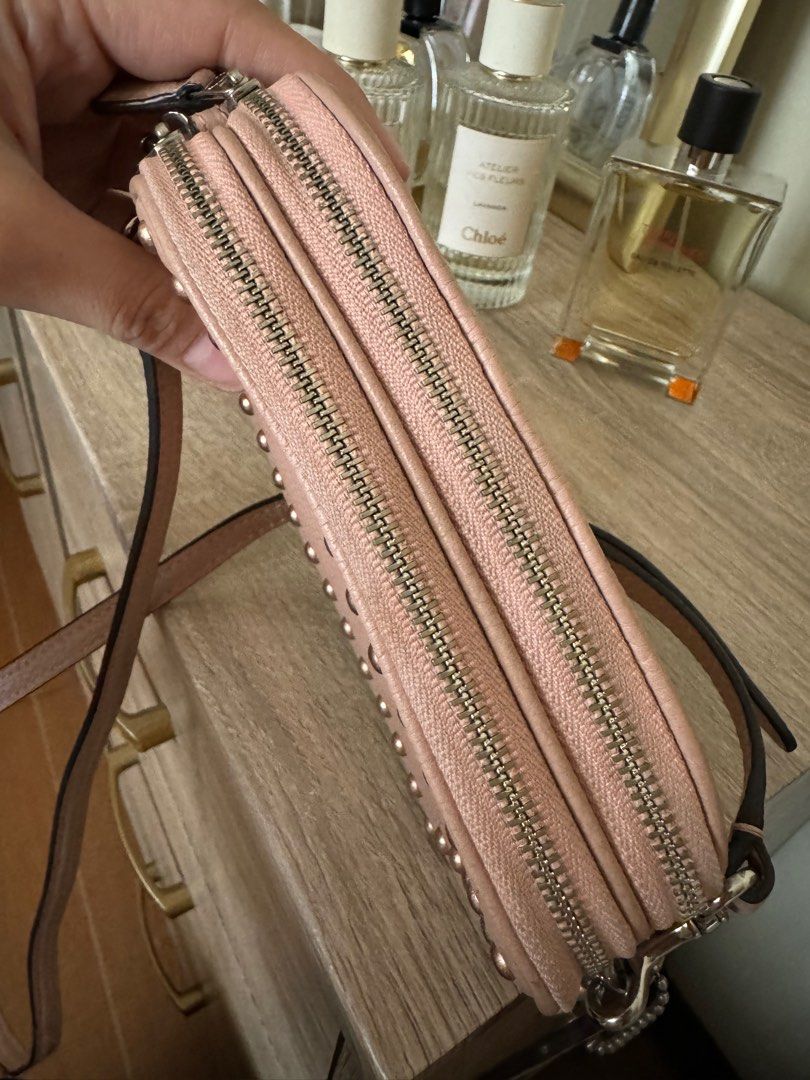Coach crossbody pouch with rivets (Category: Cross-body Bags) located in Quezon City. Submitted by mmmcat (Listing ID 1291937634, Image 2). Description: Polished pebble leather with lacquer rivets Double zip compartments Inside credit card slots Zip top closure Fabric lining Adjustable leather strap for shoulder or crossbody wear L 7.5” x H 4.5” x W 2.5”.