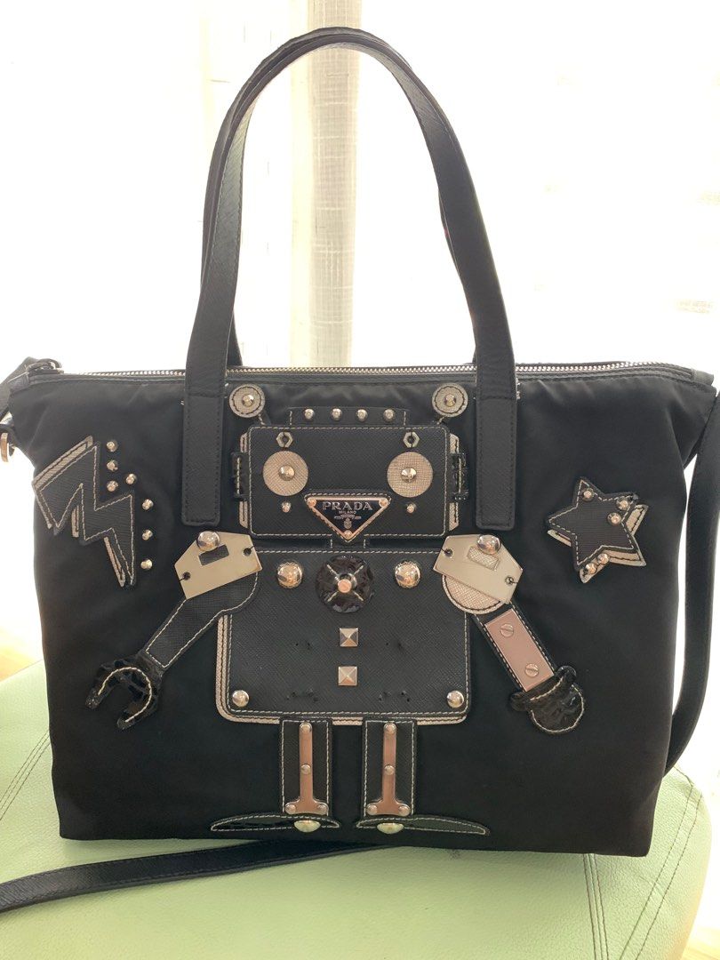 Prada Robot Bag (Category: Luxury Bags & Wallets) located in San Fernando. Submitted by butterflymom16 (Listing ID 1297710333, Image 1). Description: Prada Tessuto Robot Bag Color Black With long strap Can be worn as hand bag and crossbody bag. Outer and Inner Zipper are intact Bought in Changi Airport Flaws: other parts removed as seen on the last photo. Complete: Paper Bag, Dustbag and cards .