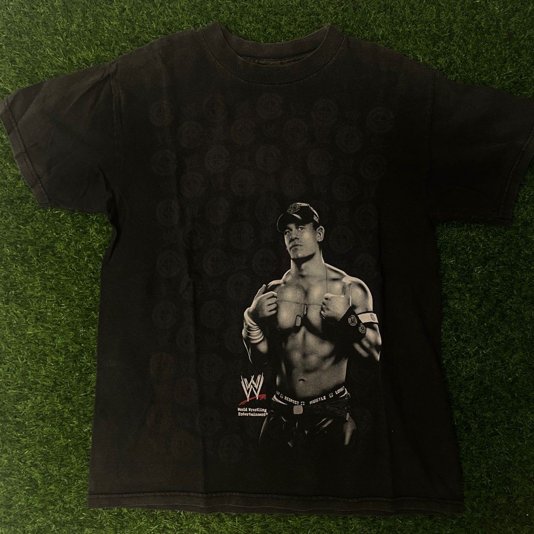 WWE John Cena Solo Shirt (Category: Community) located in Quezon City. Submitted by emporium.vtg (Listing ID 1298366812, Image 2). Description: World Wrestling Entertainment John Cena Solo Mega Print Black Shirt Cut Tag / Single Stitch Neck Size Medium Dimensions: 19.5”x27” Issue: minor loose stitch on neck & good fade.