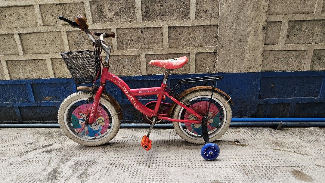 Kid's Disney Princess Bike (Category: Bicycles) located in Quezon City. Submitted by kardinalfire (Listing ID 1299323322, Image 2). Description: Kid's Disney Princess Bike - Well Used - Training wheels included - Some parts have rust but will brush off - Chain is intact - Wheels would need to be replaced - Sold as is #bike #disneyprincess #kidsbike.