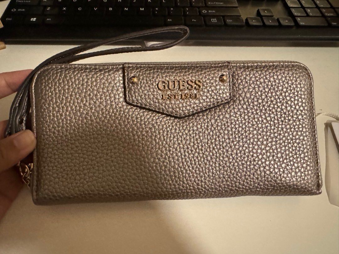 Original Guess Long Wallet - Silver with Gold Hardware (Category: Wallets & Card holders) located in Las Pinas. Submitted by melc1895 (Listing ID 1299542885, Image 1). Description: Price Negotiable Brand New Original Guess Eco ♻️ With 12 Card Slots With external and internal zipper/pockets Silver color with gold hardware.