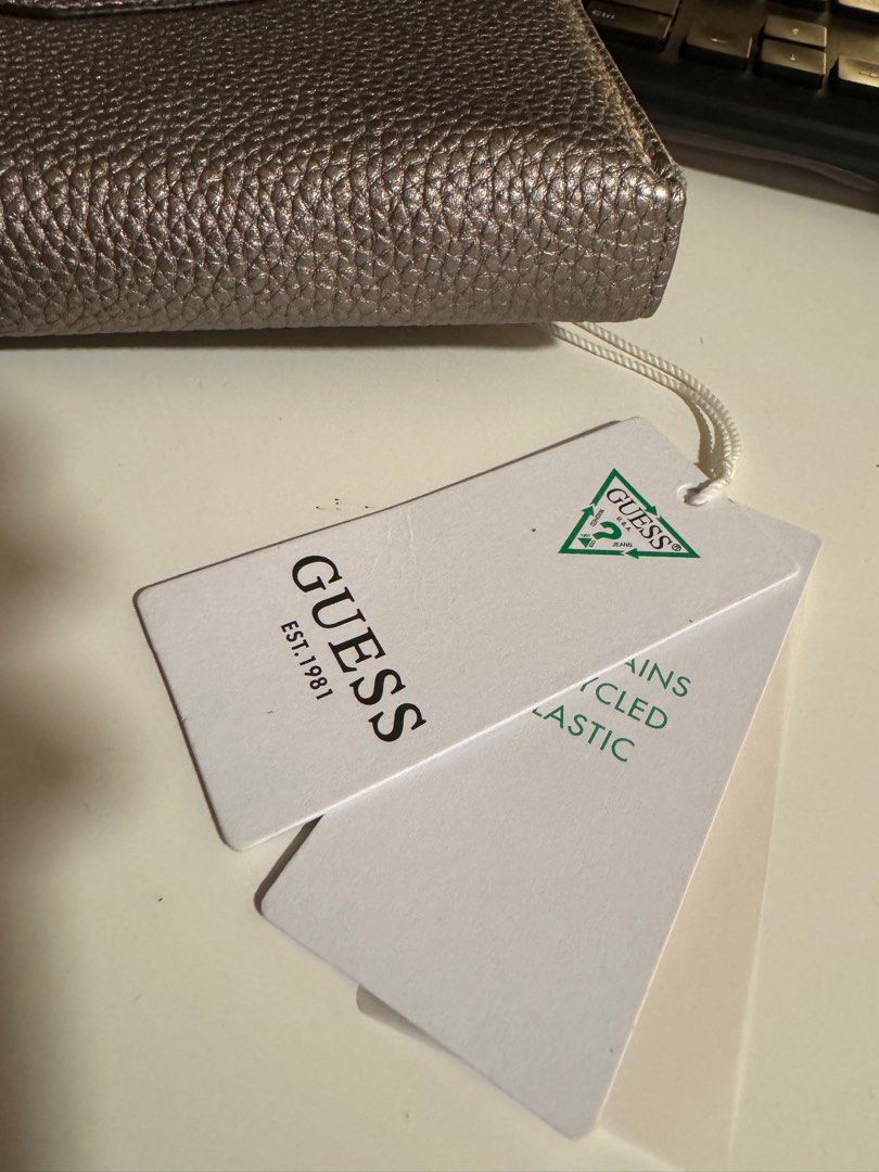 Original Guess Long Wallet - Silver with Gold Hardware (Category: Wallets & Card holders) located in Las Pinas. Submitted by melc1895 (Listing ID 1299542885, Image 2). Description: Price Negotiable Brand New Original Guess Eco ♻️ With 12 Card Slots With external and internal zipper/pockets Silver color with gold hardware.