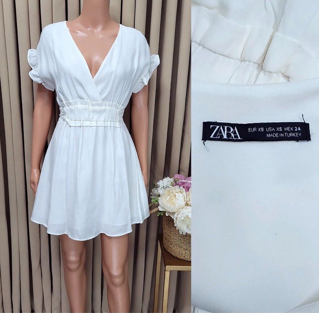 Zara White V Neck Dress (Category: Dresses) located in Pasig City. Submitted by misisfinds (Listing ID 1299768263, Image 1). Description: Garterized waist can fit xs to medium (24-32 inches waistline) Shoulder to hem length: 32 inches.