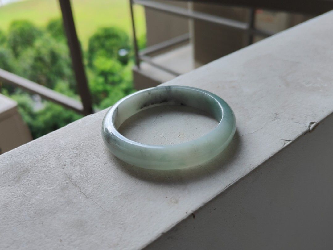 Jade bangle (Category: Precious Stones) located in Singapore. Submitted by mllms (Listing ID 1296413638, Image 2). Description: Grade A jadeite comes with cert 57-12-7.5 底子细腻，没有颗粒感。一点绿底色带乌鸡。乌鸡色线。特色镯 性价比高.