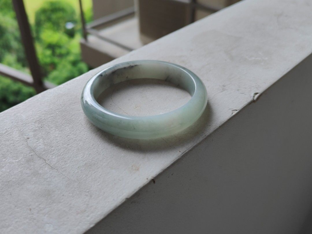 Jade bangle (Category: Precious Stones) located in Singapore. Submitted by mllms (Listing ID 1296413638, Image 1). Description: Grade A jadeite comes with cert 57-12-7.5 底子细腻，没有颗粒感。一点绿底色带乌鸡。乌鸡色线。特色镯 性价比高.