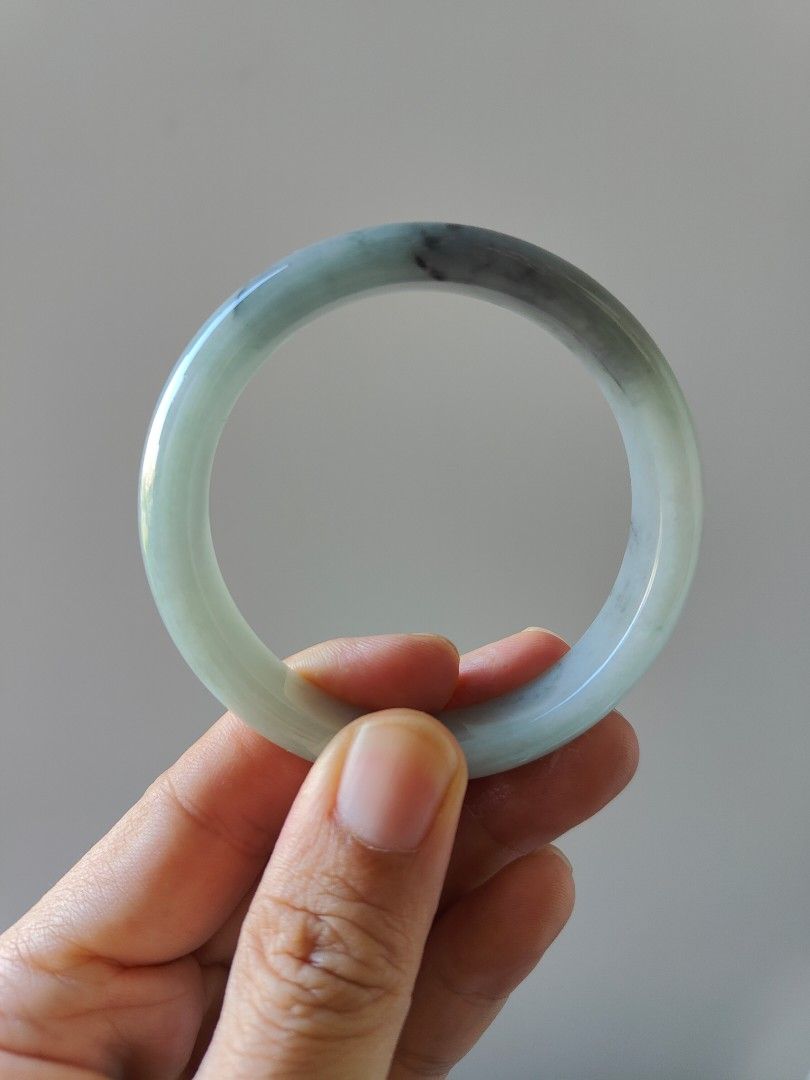 Jade bangle (Category: Precious Stones) located in Singapore. Submitted by mllms (Listing ID 1296413638, Image 5). Description: Grade A jadeite comes with cert 57-12-7.5 底子细腻，没有颗粒感。一点绿底色带乌鸡。乌鸡色线。特色镯 性价比高.