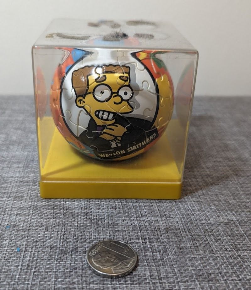 THE SIMPSONS Puzzleball Waylon Smithers 60 pcs (Category: Board Games & Puzzles) located in Manila. Submitted by matrixfinds (Listing ID 1297054766, Image 1). Description: The Simpsons Character: Waylon Smithers Brand: Ravensburger Puzzle Ball Year: 2007 Pieces: 60 The puzzle is already finished and it is contained inside a small acrylic box for display. Top of the box has some marks/damages (see pictures) SOLD AS IS .