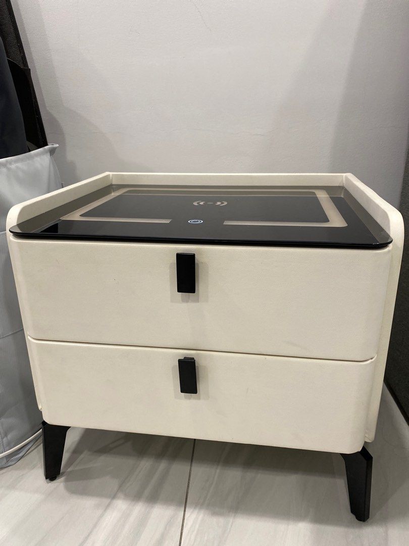 Bedside table Smart (Category: Other Home Furniture) located in Ampang. Submitted by beesue (Listing ID 1296246486, Image 1). Description: Smart bedside table, solid wood, white color with tempered glass on top. Three color lights and can change light brightness. Support wireless charging. Fully functioning and no scratches or dented. Condition 9.9/10 Reason to sell: wanted to change bedroom style, no longer in need. .