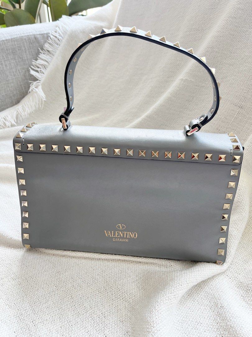 Valentino bag rockstud bag two way (Category: Luxury Bags & Wallets) located in Makati City. Submitted by loveeph (Listing ID 1189551263, Image 2). Description: Selling from my personal collection Orig VALENTINO Studded Bag in Calfskin (Gray Blue) 2-way Bag 💯 with detachable strap. Inclusion: care cards and extra rockstuds. Slightly used so please manage expectations. I would consider this bag as ranked B (slight signs of usage) 10.5" L x 6" H x