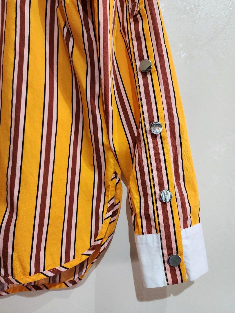 MAJE Orange Striped Long Sleeve (Category: Luxury Apparel) located in Quezon City. Submitted by chrizcboutique (Listing ID 1302942967, Image 2). Description: MAJE Striped Orange with burgundy size 1 can fit small to medium built with multiple stud in sleeve Measurements done in flat shoulder to shoulder approx 14 inches armpit to armpit approx 18 inches length approx 24.5 inches condition still in prestine condition 10/10..like NEW no flaws, no p