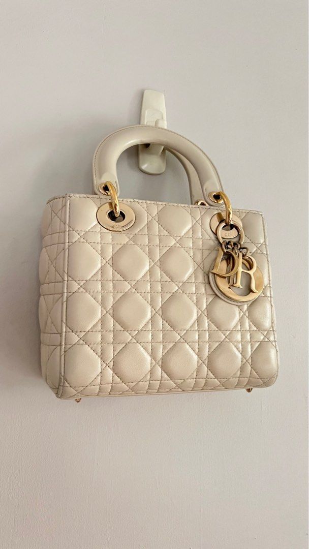 Lady Dior Small in Latte 🤍 (Category: Luxury Bags & Wallets) located in Rizal. Submitted by pink.dreams (Listing ID 1303134919, Image 1). Description: Perfect shade of off white for neutral/everyday wear Very minor signs of wear like scratches on the charms but this is typical for all lady dior bags Comes with a provided chain strap that compliments it well Includes bag and chain only 10000% guaranteed authentic.