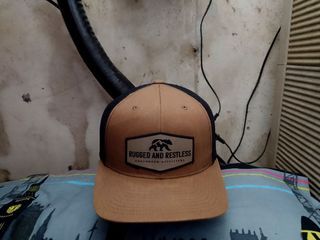 RUGGED AND RESTLESS CONUNDRUM OUTFITTERS By The Classics Yupoong, Adjustable Snapback Trucker Hat/Net Cap
