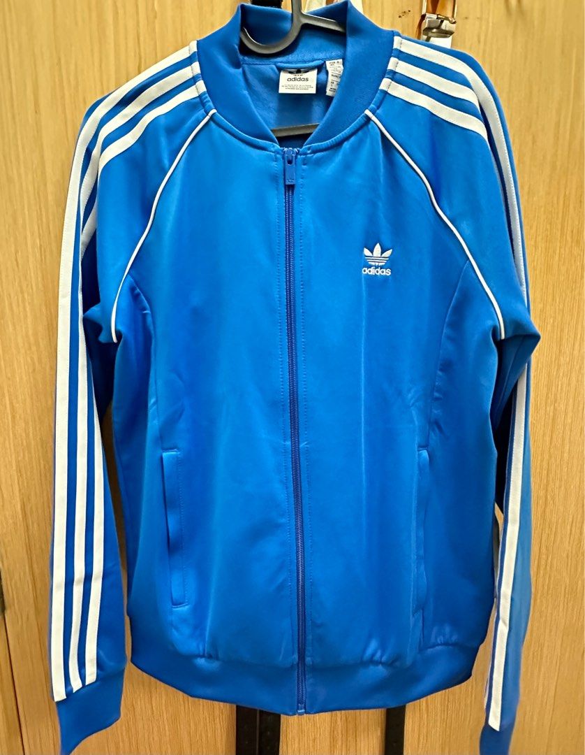 Adidas Jacket (Category: Coats, Jackets and Outerwear) located in Singapore. Submitted by geri7 (Listing ID 1304456549, Image 1). Description: ORIGINAL ADICOLOR CLASSICS SST TRACK JACKET Size: L Condition: Good as new, only wore once RFS: Size is a but big for me, hence selling Slim fit Full zip with ribbed stand up collar 70% polyester (recycled), 30% cotton Zip pockets Ribbed hem and cuffs Colour: Blue Bird / White.
