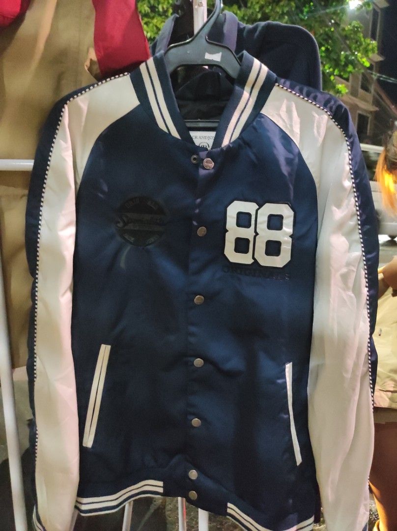 Jack & Jones Bomber Jacket (Category: Coats, Jackets and Outerwear) located in Quezon City. Submitted by chambie0426 (Listing ID 1301801201, Image 1). Description: Brand: Jack & Jones Color: Navy Blue & White (2 tone) Size: L on tag Dimes: 23 width by 26 length Condition & Color rate: 9.3/10 Honest issue: Lints but already removed, washable stain & needs wash Authenticity: Legit Additional details: Embroidered logos, engraved brand on every butto