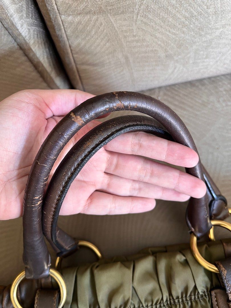 Prada Handbag (Category: Luxury Bags & Wallets) located in Marikina City. Submitted by declutterisse (Listing ID 1301888298, Image 2). Description: - used but not abused. There are some rubs tho, but it kinda just adds character to the bag esp since the nappa leather is brown. - there are cracks/slight peelings on the top handle, will give u a twilly-like scarf for free to wrap those. - slight fading on the protective feet - very spacious - can w