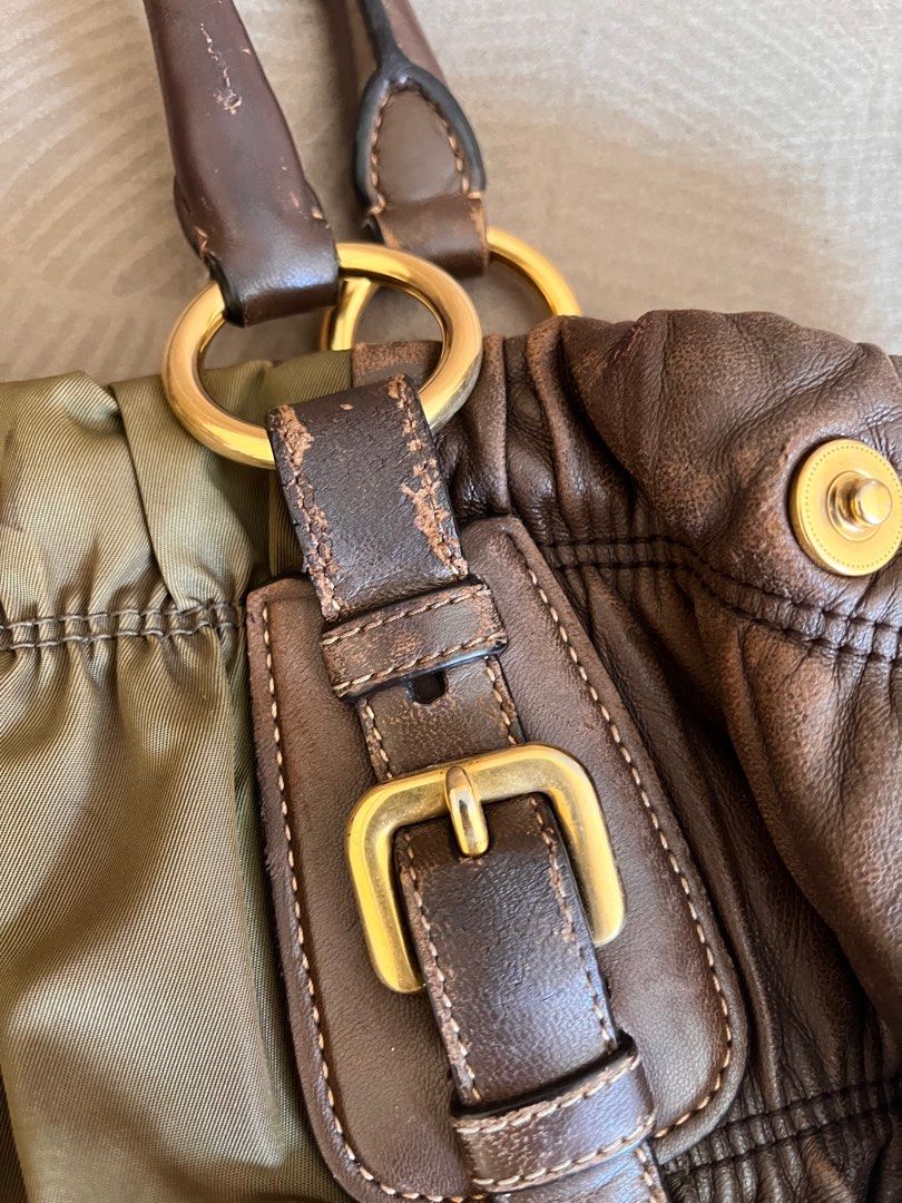 Prada Handbag (Category: Luxury Bags & Wallets) located in Marikina City. Submitted by declutterisse (Listing ID 1301888298, Image 3). Description: - used but not abused. There are some rubs tho, but it kinda just adds character to the bag esp since the nappa leather is brown. - there are cracks/slight peelings on the top handle, will give u a twilly-like scarf for free to wrap those. - slight fading on the protective feet - very spacious - can w
