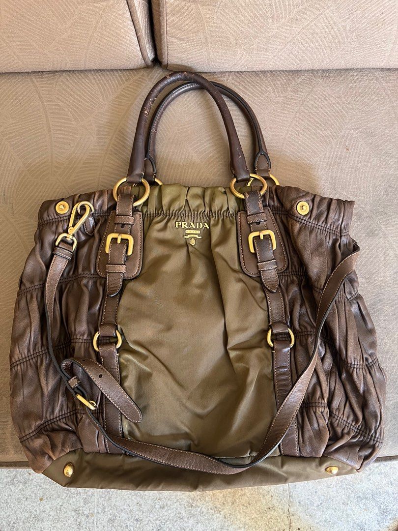 Prada Handbag (Category: Luxury Bags & Wallets) located in Marikina City. Submitted by declutterisse (Listing ID 1301888298, Image 1). Description: - used but not abused. There are some rubs tho, but it kinda just adds character to the bag esp since the nappa leather is brown. - there are cracks/slight peelings on the top handle, will give u a twilly-like scarf for free to wrap those. - slight fading on the protective feet - very spacious - can w