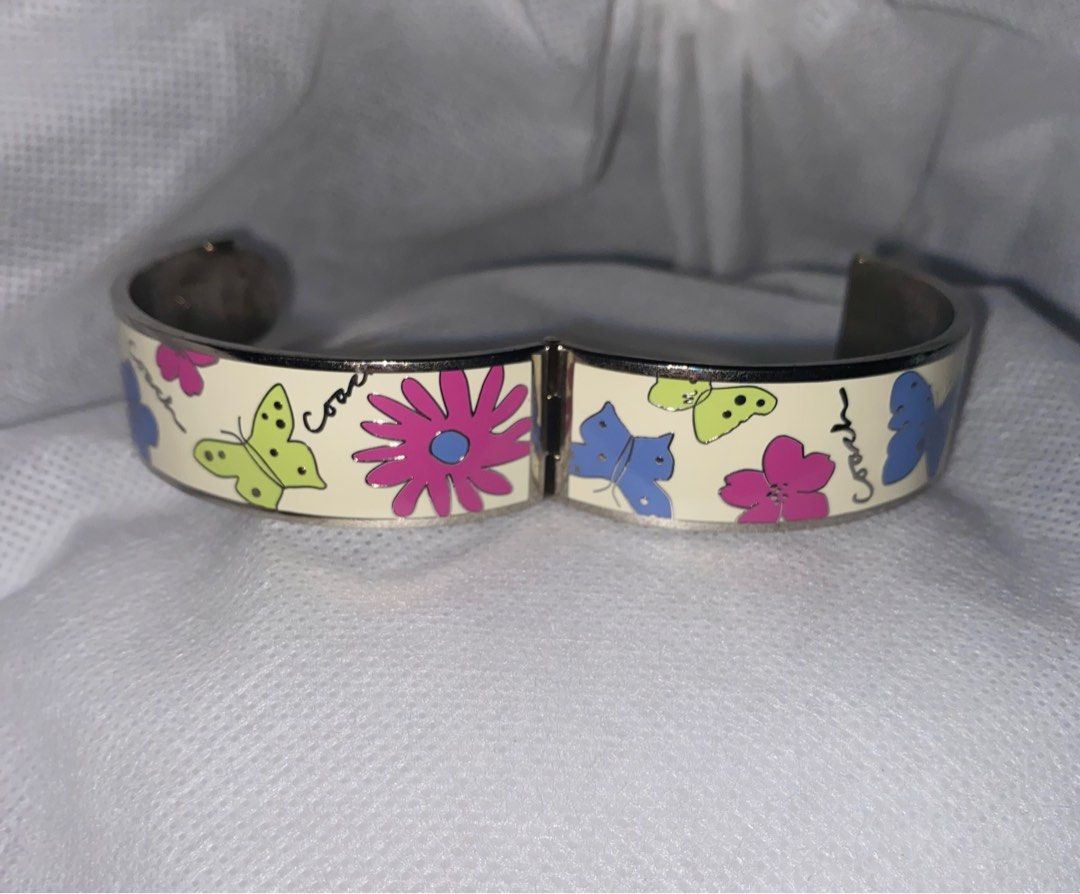 COACH est1941 Round Button Close Off-White Enamel w/Colored Butterflies Bangle (Category: Luxury Accessories) located in Bulacan. Submitted by declutterwithmeee__ (Listing ID 1308629146, Image 3). Description: ⭕️ Bangle is about 3/4 inches wide ⭕️ Weighs 68.6grams MOP: Gcash MOD: J&T / SCO .