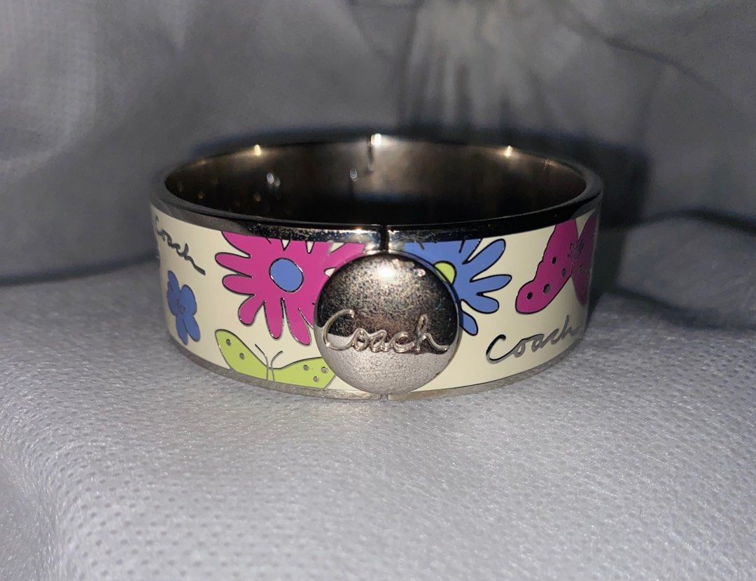 COACH est1941 Round Button Close Off-White Enamel w/Colored Butterflies Bangle (Category: Luxury Accessories) located in Bulacan. Submitted by declutterwithmeee__ (Listing ID 1308629146, Image 2). Description: ⭕️ Bangle is about 3/4 inches wide ⭕️ Weighs 68.6grams MOP: Gcash MOD: J&T / SCO .