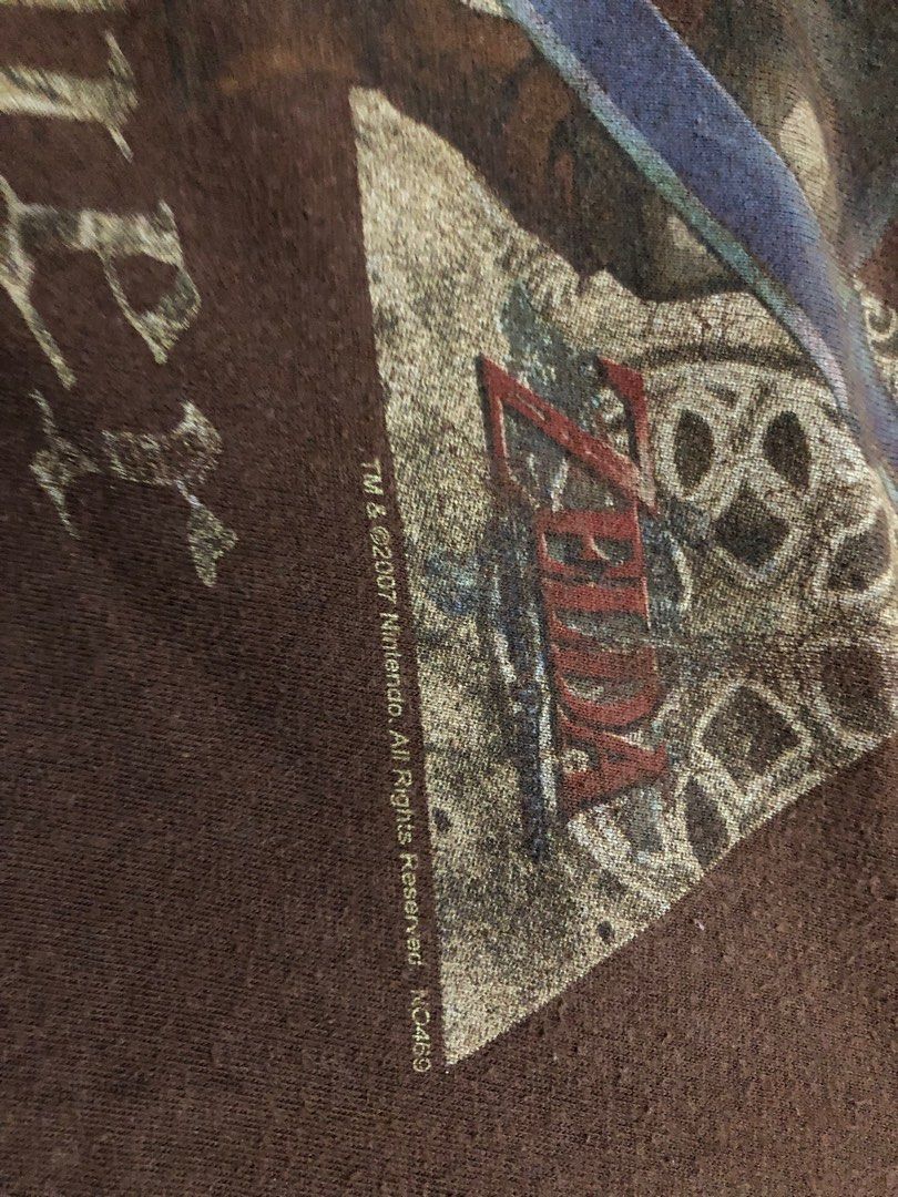 2007 Zelda (Gaming Shirt) (Category: Tshirts & Polo Shirts ) located in Tuguegarao City. Submitted by emdisplay (Listing ID 1308963658, Image 3). Description: Zelda Take Over tag (Bootleg) ©️2007 Nintendo 20.5x26.5 to 27 / Medium Flaws: Butas o punit sa likod ng right sleeve (check photos) and uneven fadings.