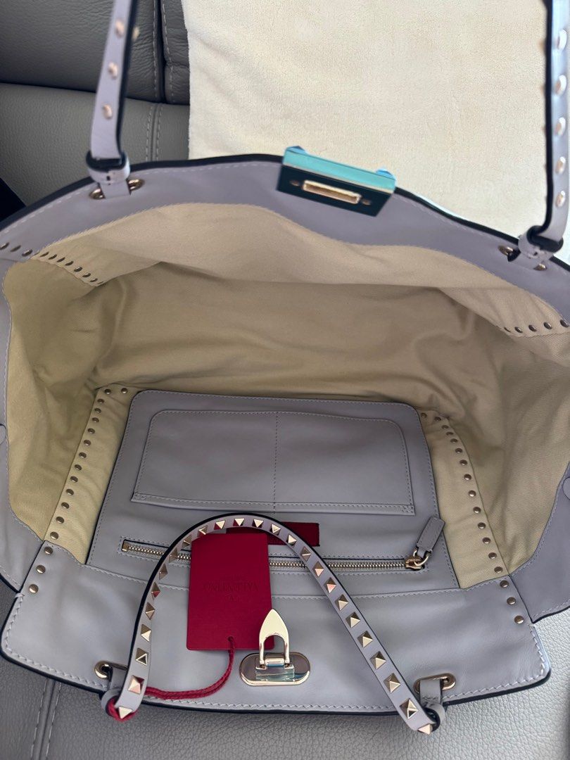 Brand New-Valentino Rockstud Medium leather tote - Light Grey (Category: Bags & Wallets) located in Singapore. Submitted by lin4s (Listing ID 1306559752, Image 3). Description: Brand New- Authentic Classic Valentino Garavani Rockstud Medium Tote in light grey color. Comes in stud straps. A little bit of baby blue color. Selling as I am clearing my wardrobe space. Boutique selling at SGD 4360. See last pics. Good size for office or casual. All in 