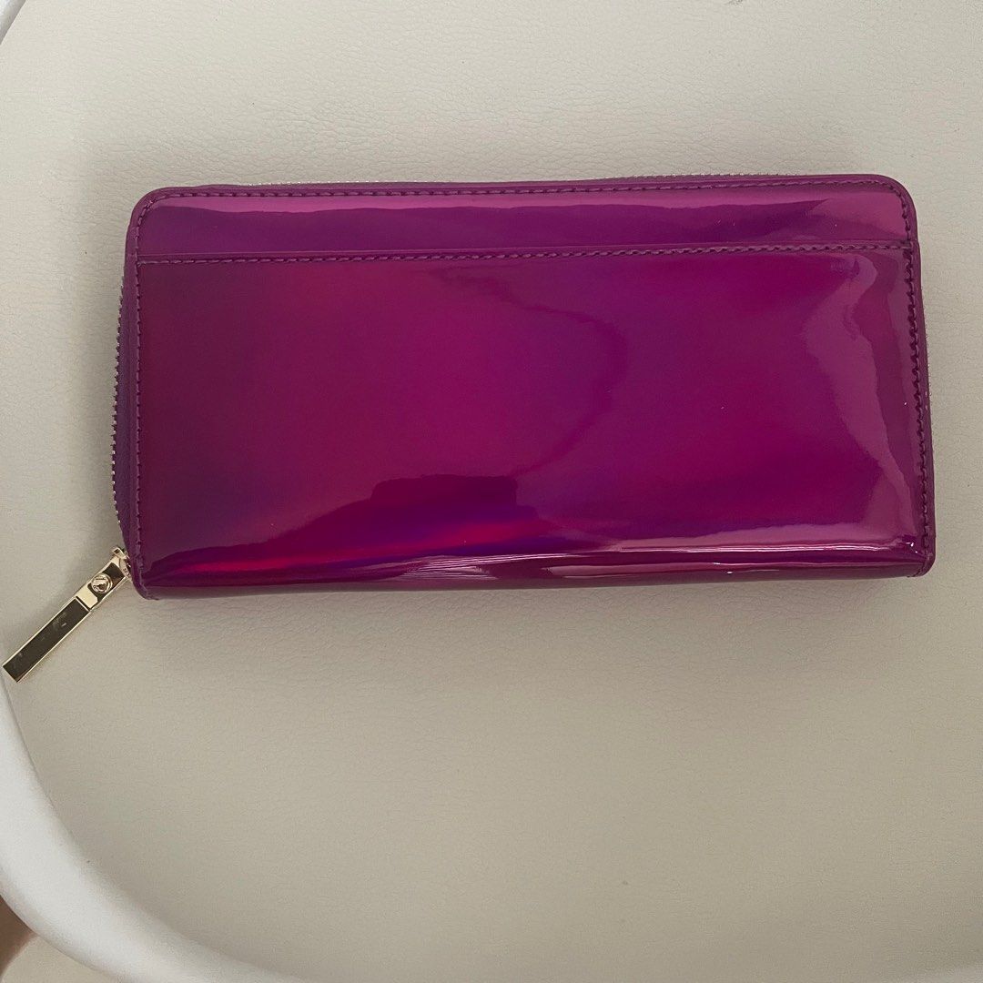 Kate Spade Purple Patent Long Wallet (Category: Wallets & Card holders) located in Pasig City. Submitted by eenamagg (Listing ID 1310499152, Image 3). Description: Brand New never worn Lost care card and dust bag Wallet only and tag Original Kate Spade. Color is called BAJAROSE. Model number PWRU5197 Original price is ₱8000 My price is ₱3000.