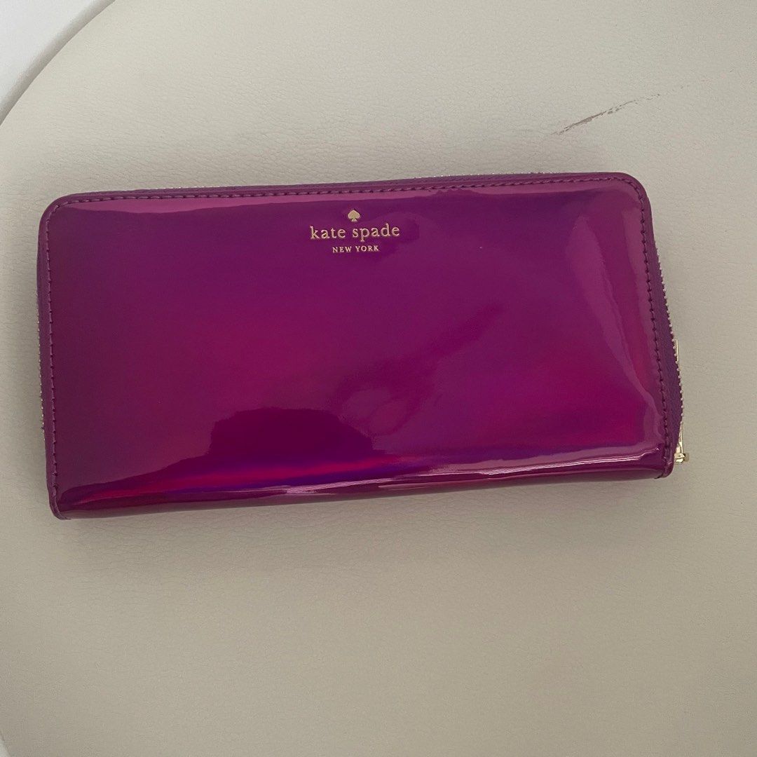 Kate Spade Purple Patent Long Wallet (Category: Wallets & Card holders) located in Pasig City. Submitted by eenamagg (Listing ID 1310499152, Image 2). Description: Brand New never worn Lost care card and dust bag Wallet only and tag Original Kate Spade. Color is called BAJAROSE. Model number PWRU5197 Original price is ₱8000 My price is ₱3000.
