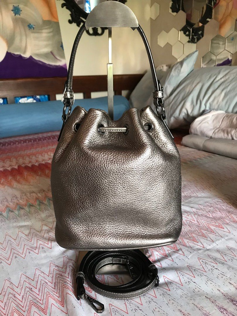 Oryany bucket bag with sling (Category: Luxury Bags & Wallets) located in Santa Rosa. Submitted by rina.rina3 (Listing ID 1311540811, Image 2). Description: Silvery gold Oryany bucket bag with detachable sling Preowned from Korea Gunmetal excellent hardwares Very soft but thick leather With minimal unnoticeable flaw - scrape in front hence selling low (see last picture) Bag dimensions LXWXH 7.5in x 5in x 9in Bag height including top handle is 13.