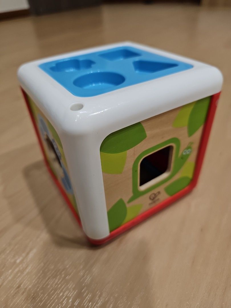 Hape Shape Sorting Box (Category: Infant Playtime) located in Singapore. Submitted by ridefully (Listing ID 1316018317, Image 1). Description: FUN SORTING GAME FOR KIDS: Place the shaped pegs into the right holes. When you are done, put away all pieces in the shape holder on top of the box FOUR GARDEN CREATURES: Each shape corresponds with a garden creature; a moth, spider, butterfly and snail and is designed to fit through a matching hole on the