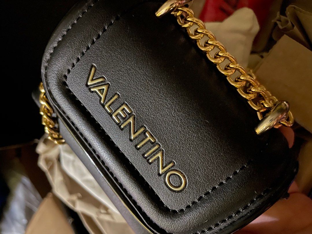 Valentino Moss Tiny Flap Micro Sling (Category: Luxury Bags & Wallets) located in Manila. Submitted by thecluttershop_2018 (Listing ID 1313383894, Image 2). Description: Valentino Bags’ Moss cross body bag is a compact style for carrying small everyday essentials. The faux leather design has a chunky gold-tone chain strap that can be doubled for over the shoulder wear or extended for cross body styling. A tonal patent trim on the front and logo l