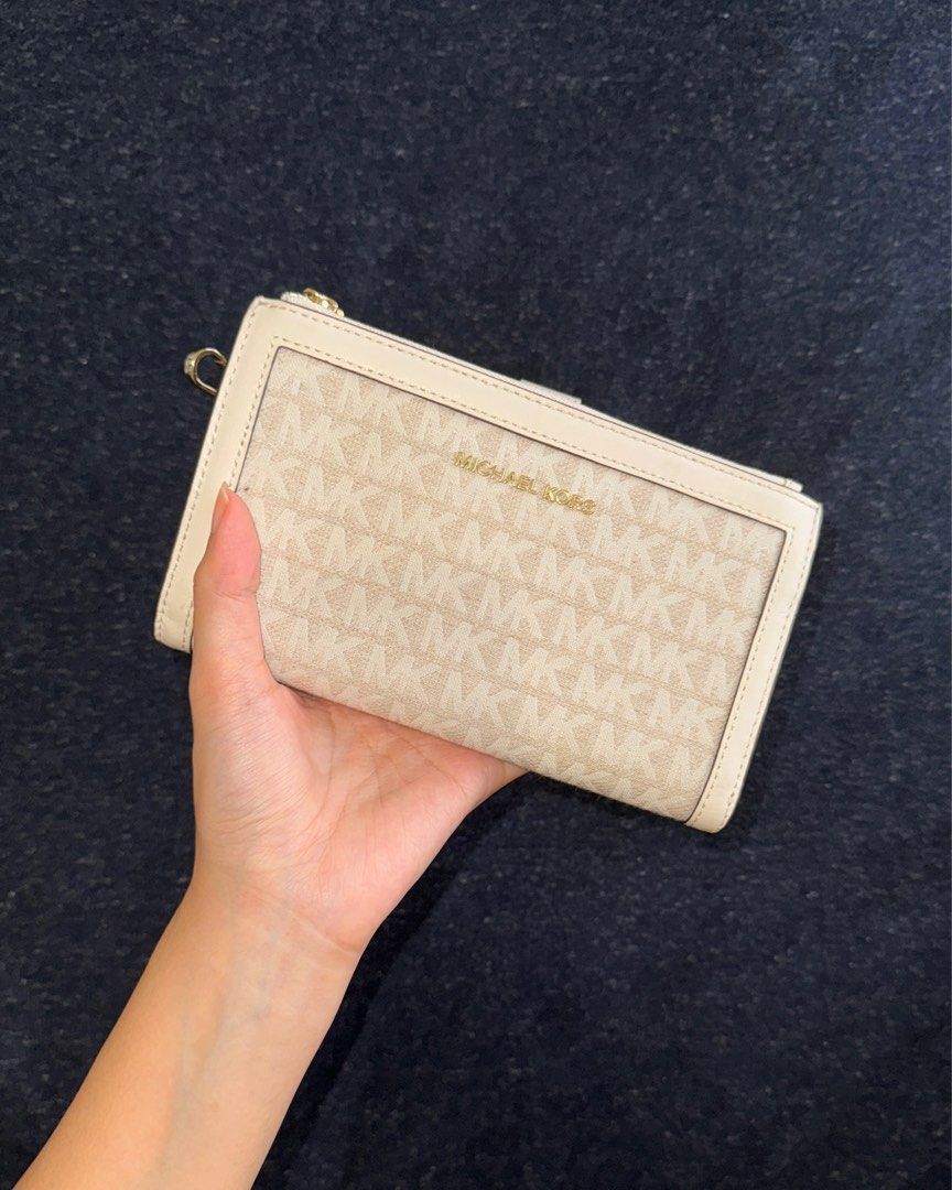 Michael Kors Logo Smartphone Wallet (Vanilla) (Category: Luxury Bags & Wallets) located in Mandaluyong City. Submitted by fromfran (Listing ID 1312724322, Image 1). Description: - Haven’t been using it - As is. I haven’t kept the original packaging - Bought in the US - No issues ♡ - Fits an iPhone 15 Pro with case - With strap - Gold zippers - Shipping to be shouldered by the buyer.