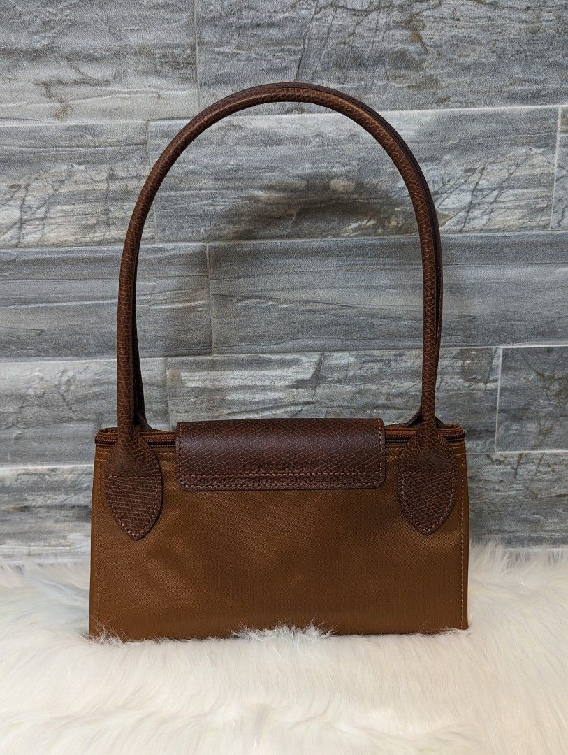 Longchamp Le Pliage Green Handbag M Cognac (Category: Luxury Bags & Wallets) located in Manila. Submitted by facet.ornament (Listing ID 1313017513, Image 2). Description: Authentic 👜💯🪭 Longchamp Le Pliage Green Handbag M Cognac Ginza, Japan bought 🇯🇵 Note: Mall price - PHP 9,800 • Top long handle bag • Longchamp style number: L2605919504 • Dimensions : 11 in (L - measured at the base of the bag) x 10.4 in (H) x 6.1 in (W) • Interior: Patch p
