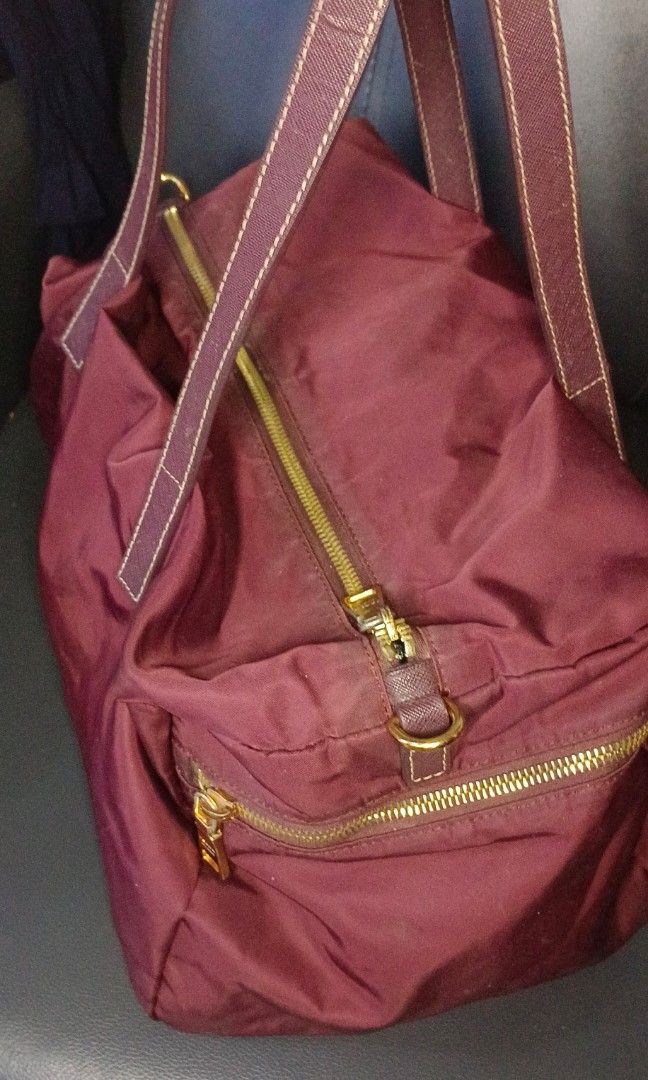 PRADA Red Tessuto Boston Bag (Category: Luxury Bags & Wallets) located in Legazpi City. Submitted by georgepineda791 (Listing ID 1313113628, Image 3). Description: This Prada Boston bag boasts a durable nylon body, complemented by stylish flat leather handles. The top zip closure ensures the safety of your belongings, while the interior zip pocket provides extra storage for smaller items. This bag shows minor signs of wear, yet remains good condi