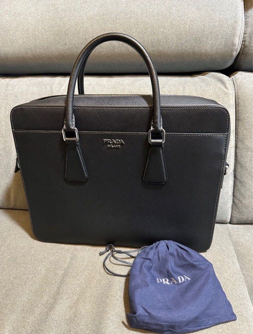PRADA BLACK SAFFIANO LEATHER BRIEFCASE BAG (Category: Bags & Wallets) located in Singapore. Submitted by RibbonJelly (Listing ID 1319335030, Image 1). Description: As good as new. Used only 2-3 times for work event. Shoulder strap is new and unused before. Briefcase in Black Saffiano leather. Prada lettering in metal. Comes with dust bag! Please pm to discuss meet up location if keen. Low ballers will not be entertained!.