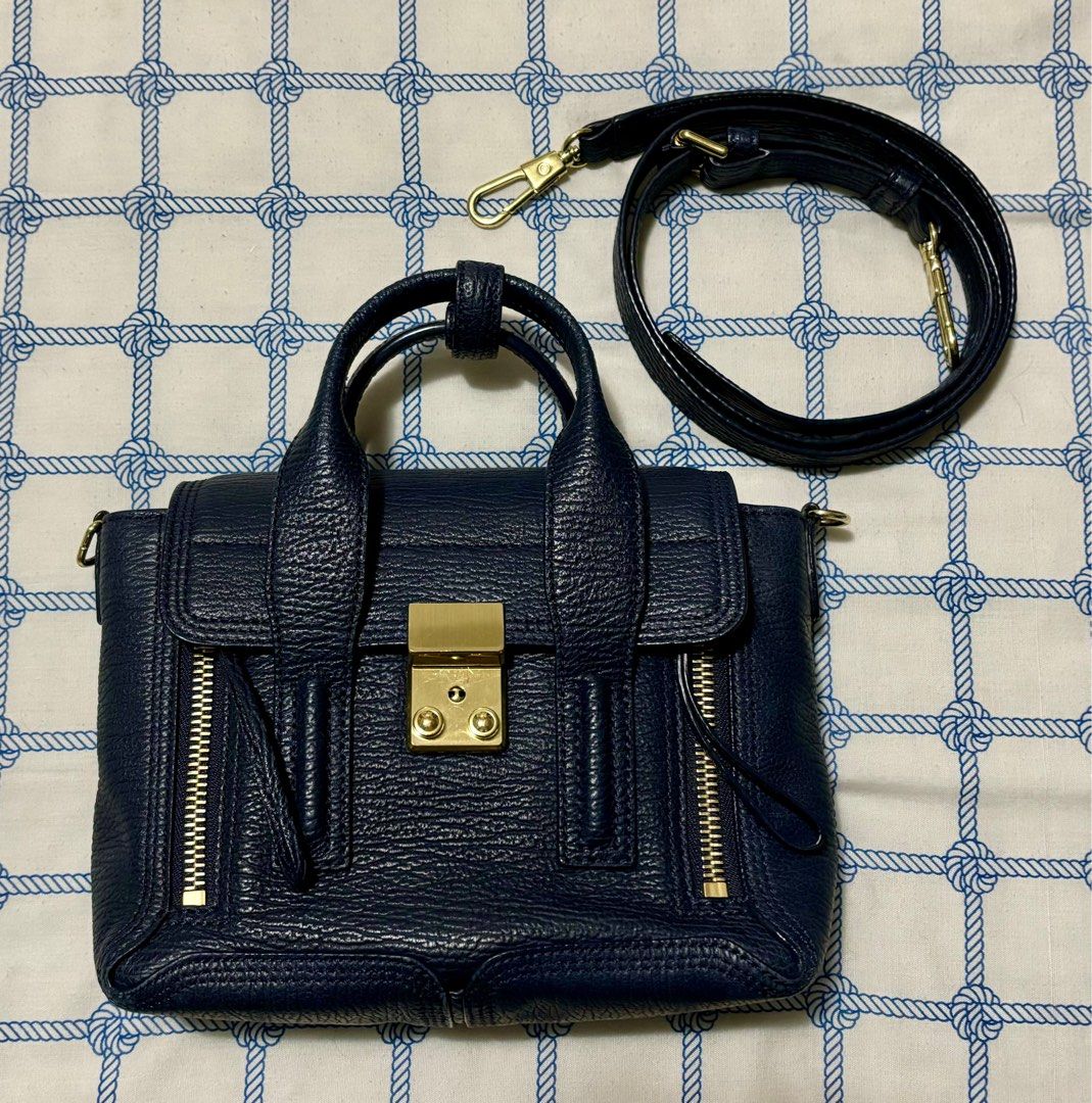 Sale! Pashli Phillip Lim (Category: Cross-body Bags) located in Taguig. Submitted by museumile (Listing ID 1320691425, Image 1). Description: Authentic Pashli by Phillip Lim two-way bag in dark blue. Very cute! Comes with detachable & adjustable strap. Bought in LA for P31k. RFS: Not using anymore. Size: 10x8x3 inches. No major flaws. Minor rub only on back bottom corner, scratches on front hardware (see photos). Clean inner lining. Zippers are a
