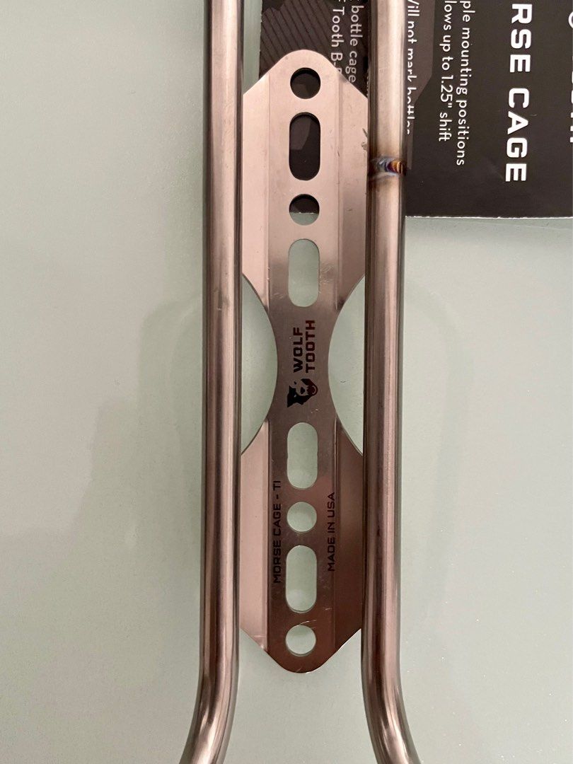 WOLFTOOTH MORSE TITANIUM BOTTLE CAGE (Category: Bicycles) located in Taguig. Submitted by ridegravel94333 (Listing ID 1321532692, Image 2). Description: WOLFTOOTH MORSE TITANIUM BOTTLE CAGE selling as set(2 pcs) 8000.00 The Wolf Tooth Morse Cage is a versatile titanium bottle cage with a unique base plate that allows you to reposition the bottle placement on your bike. Named for its dot-dash-dot-dash mounting pattern, the Morse Cage base plate of