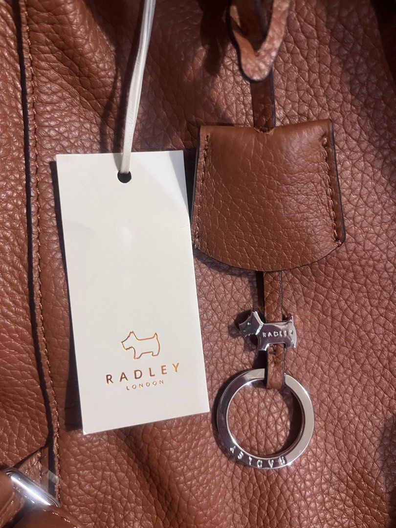 Authentic Radley london backpack (Category: Luxury Bags & Wallets) located in Paranaque City. Submitted by FLess.ph (Listing ID 1322381155, Image 2). Description: RADLEY LONDON: Brown Lorne Close Large Flap-over Backpack (₱9,500.00) Details: * Strap Drop Length: 7cm * Dimension: W26 x H33 x D17 cm * Crafted in grained leather * Square shape with cut edge detailing * Flap-over top with foil embossed Radley London logo * Hidden zip-top fastening * 
