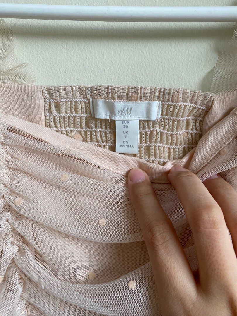 H&M blush pink ruffle puff top (Category: Blouses) located in Pasig City. Submitted by ulit.ulitph (Listing ID 1318119386, Image 2). Description: H&M blush pink Dotted top Smocked puff top ruffle Cam be offshoulder With minor black stain at the back in the photo.