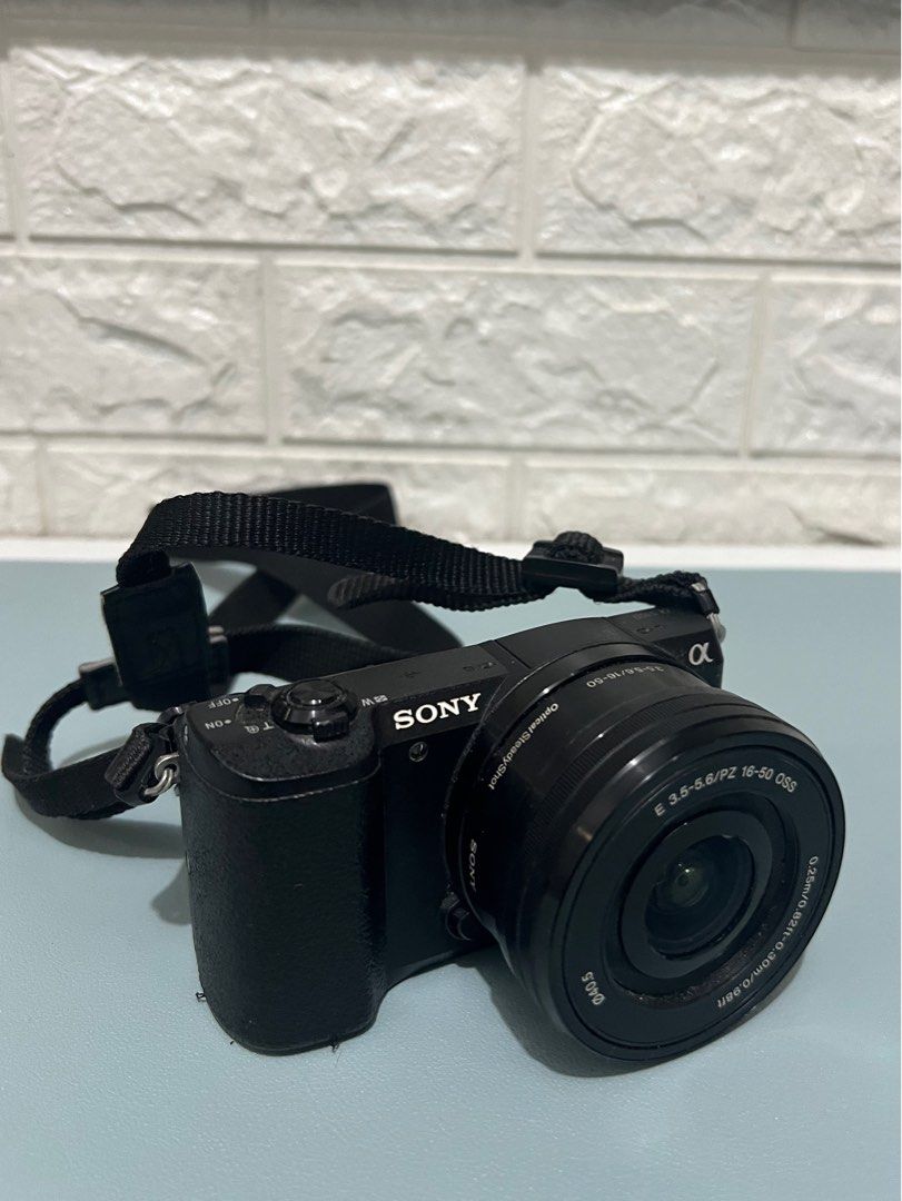 Sony Mirrorless A5100 Camera Body and Lens (Category: Cameras) located in Manila. Submitted by prelovedbyaiah (Listing ID 1318416890, Image 1). Description: Comes with charger cord and box Honest issue: No Lens cover, minimal crack (unnoticeable, doesnt affect photo output) RFS: Decluttering, not used .