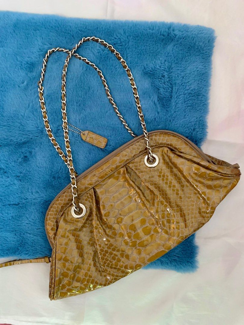 Danier Snakeskin Chain Purse Vintage Classy Shoulder Bag (Category: Luxury Bags & Wallets) located in Manila. Submitted by midcloset (Listing ID 1318606188, Image 1). Description: Does not come with original packaging. 👜 FEATURES: • Lightweight and durable • Stain and water-resistant • 2 pockets and 1 zip-pocket inside bag • Silver chain strap and detailing • Genuine leather • Shiny finish • Snakeskin-like appearance.