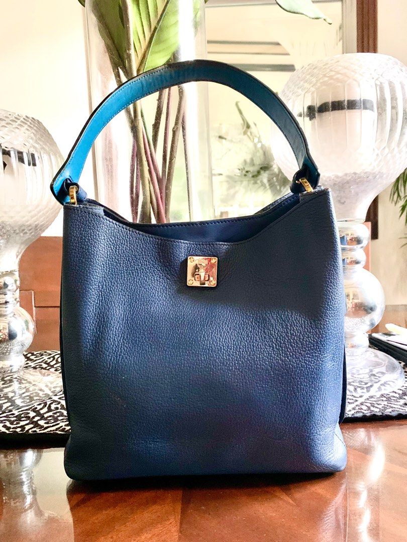 Authentic MCM Leather M (Category: Luxury Bags & Wallets) located in Guagua. Submitted by rizza4 (Listing ID 1326805601, Image 1). Description: • Navy blue • Turnable screws • No sling • from Korea • with minor flaw ,small crack handle rubber but not noticeable , front lock a little bit gold faded • since its preloved hold your expectations .