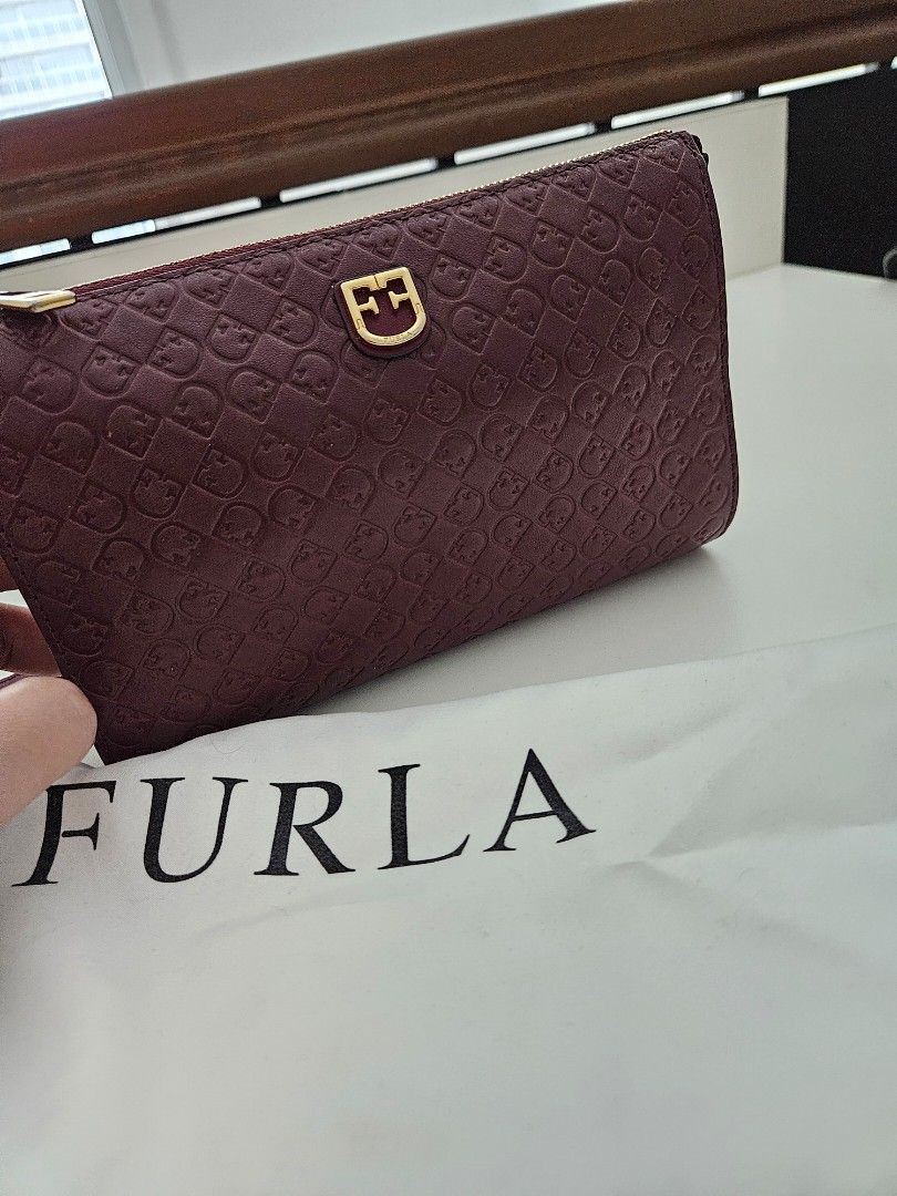 Furla small bag / WOC (Category: Luxury Bags & Wallets) located in Taguig. Submitted by rochev (Listing ID 1326740784, Image 1). Description: lightly used authentic Furla small cross bag / WOC. Measurement can be seen in the photo. There's a a slight discoloration of the zipper hardware and very slight for the logo. No scuffs. Shape is perfect. Deep red almost maroon in color. With dustbag..