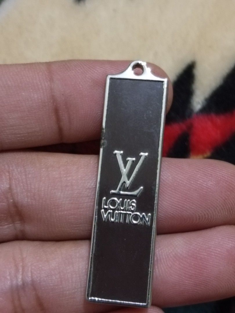 Louis Vuitton metal bag tag charm (Category: Luxury Accessories) located in Quezon City. Submitted by markgolveo (Listing ID 1326978640, Image 1). Description: Louis Vuitton metal bag tag charm chip damage on left side part.