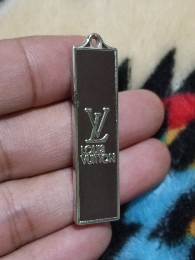 Louis Vuitton metal bag tag charm (Category: Luxury Accessories) located in Quezon City. Submitted by markgolveo (Listing ID 1326978640, Image 2). Description: Louis Vuitton metal bag tag charm chip damage on left side part.
